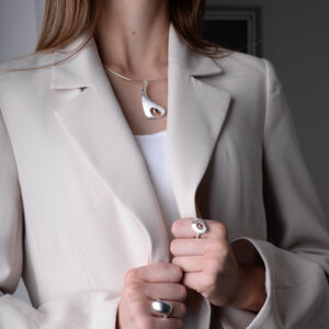 Outback Fossil Pendant in silver with sapphire set in 18ct yellow gold and diamonds, worn by model. Sculptural design inspired by the Australian outback, capturing natural contrast and refined craftsmanship.