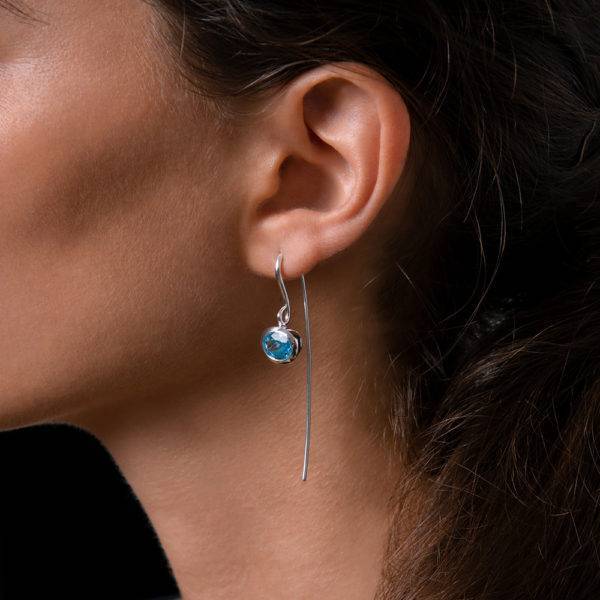 Nouvelle Lily earrings with blue topaz shown on model