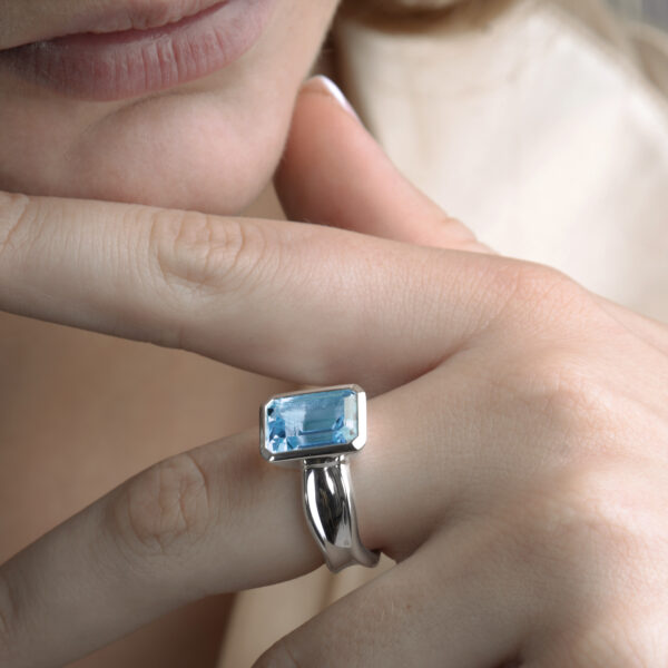The stunning Ebb Tide step ring with blue topaz is sculpted in high polished silver.