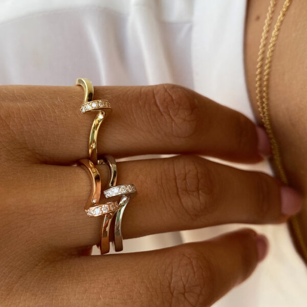 Close-up of Pirouette Diamond Rings in white, rose, and yellow gold with diamonds.