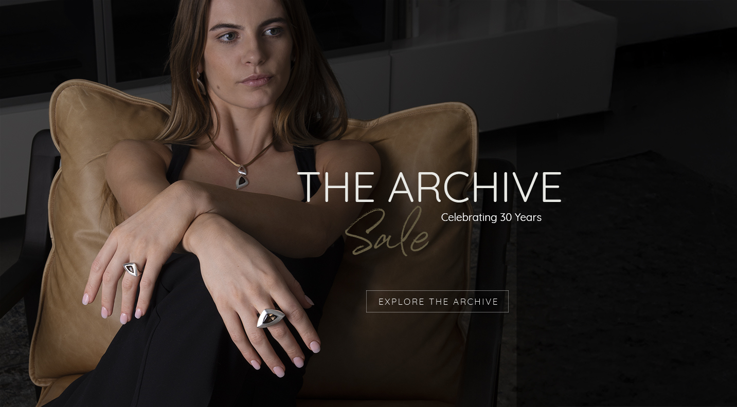 Model leaning back relaxed, wearing bold South Atlantic jewellery in polished silver by Daniel Bentley. Capturing the refined elegance and sculptural forms featured in The Archive Sale celebrating 30 years of design.