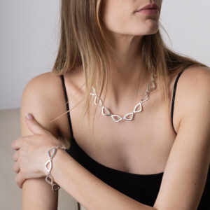 The Atlantic Necklace and Bracelet in polished sterling silver, worn by model. Refined and elegant bracelet reflecting the movement and flow of the ocean.